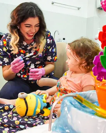 Dra. Diana Duarte acolhendo uma criança durante atendimento odontológico